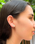 Lifestyle image of cute minimalist baseball stud earrings from the side. Lifestyle image of softball stud earrings from the side.