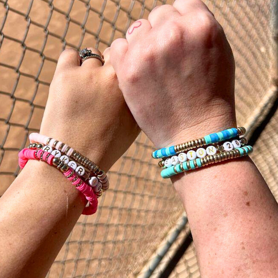 custom baseball/softball heishi bead bracelets in lifestyle picture in pink and teal