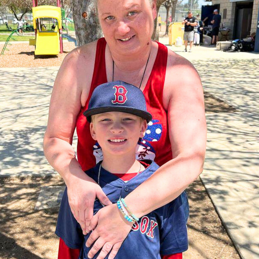 custom baseball heishi bead bracelet in teal lifestyle picture, a baseball mom is holding a baseball player